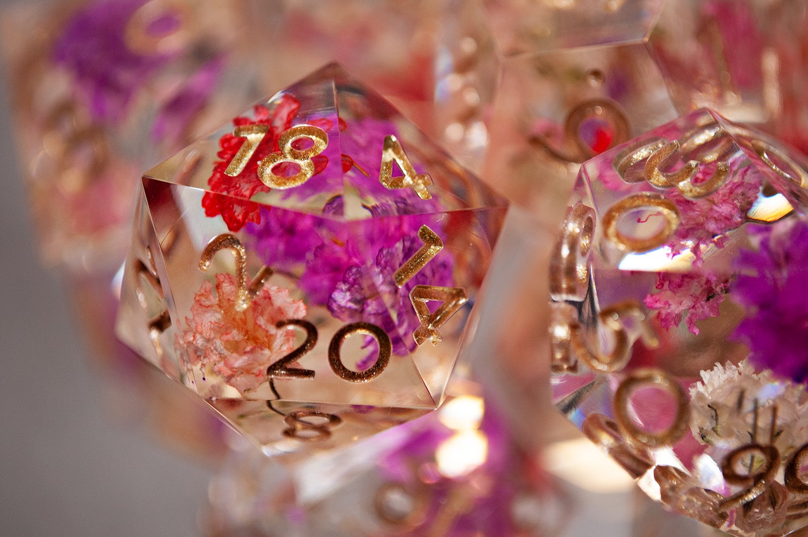 Clear dice with pink and purple dried flowers and gold numbers