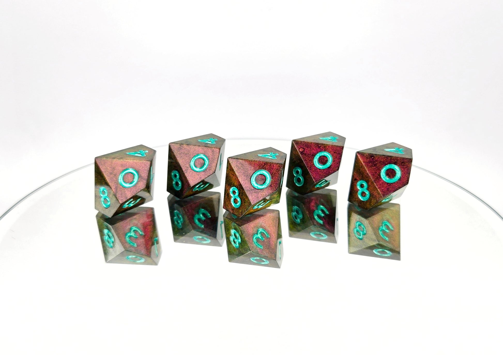 A 5d10 ttrpg dice set. The dice are a red/purple/yellow/green colorshift shimmer with metallic cool green numbering.
