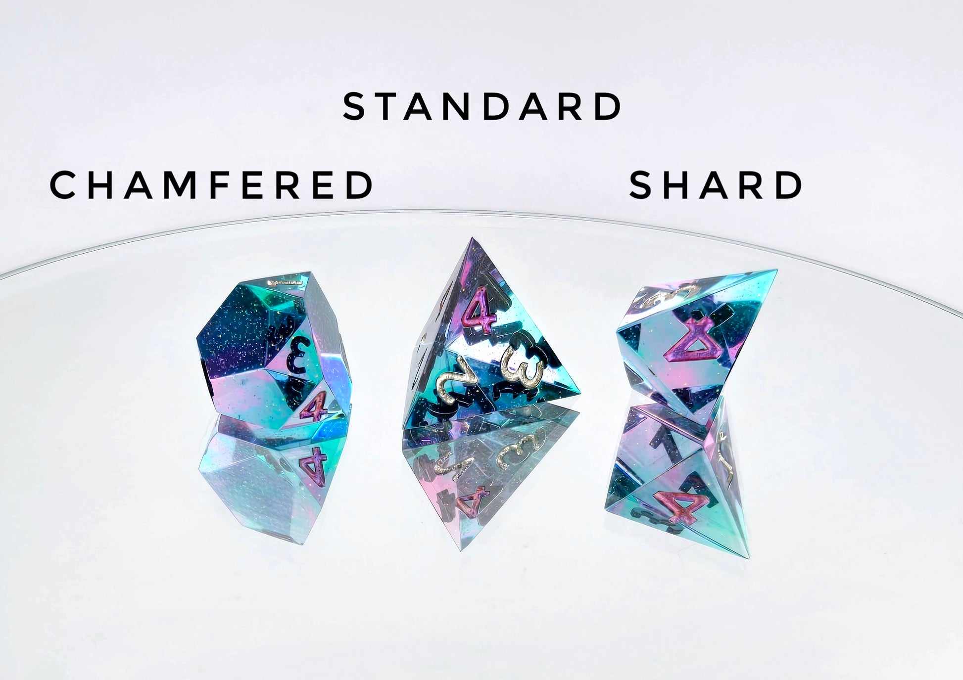 A comparison of different available d4 shapes from a ttrpg dice set. The dice are transparent pink and teal swirls which create illusions of blue and purple. The numbers are mostly sparkling silver with deep purple-pink on the high value. The text on the image reads "chamfered, standard, shard", corresponding to the shapes photographed below them.