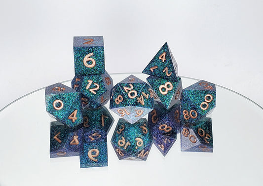 A full 7 piece polyhedral ttrpg set. The dice are densely packed blue and green colorshift glitter with rose gold inking for the symbols.