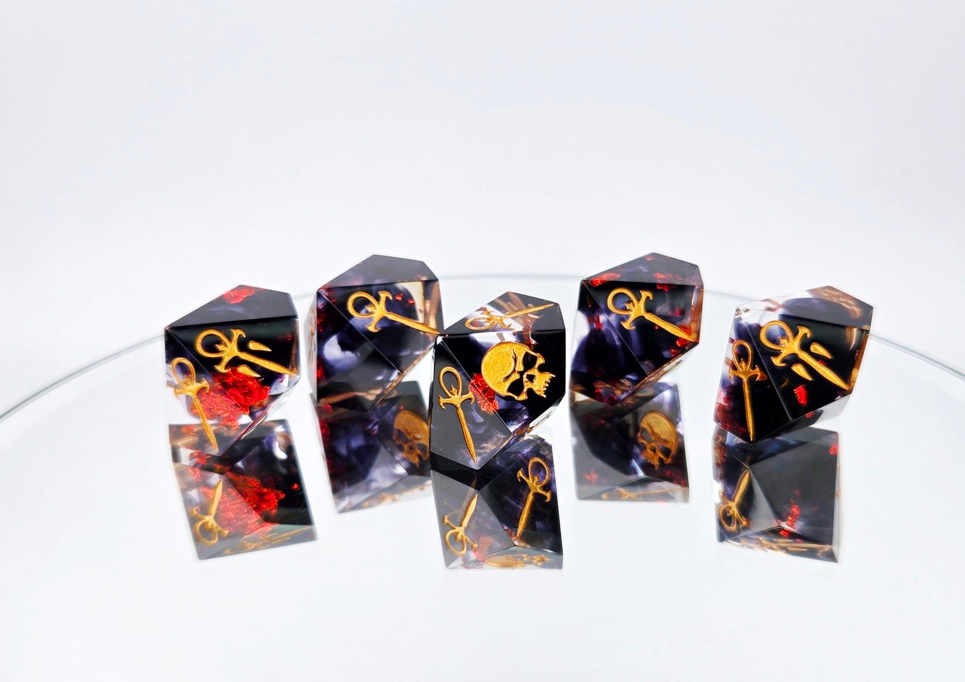 A Vampire the Masquerade Hunger style 5d10 set. The dice are clear with black ink and red foil swirled within. The symbols are inked in gold.