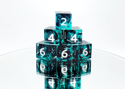 A six piece d6 ttrpg dice set. The dice are transparent teal with black ink tendrils, chunks of silver foil, and bright silver numbers.