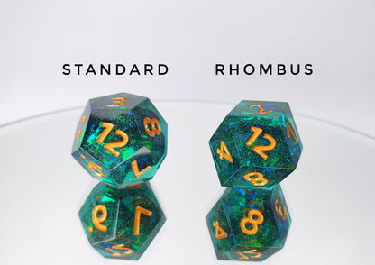 A comparison of a standard pentagonal d12 and a rhombus d12. The dice are a transparent green with reflective mylar embedded inside with super fine green glitter throughout and golden numbers.