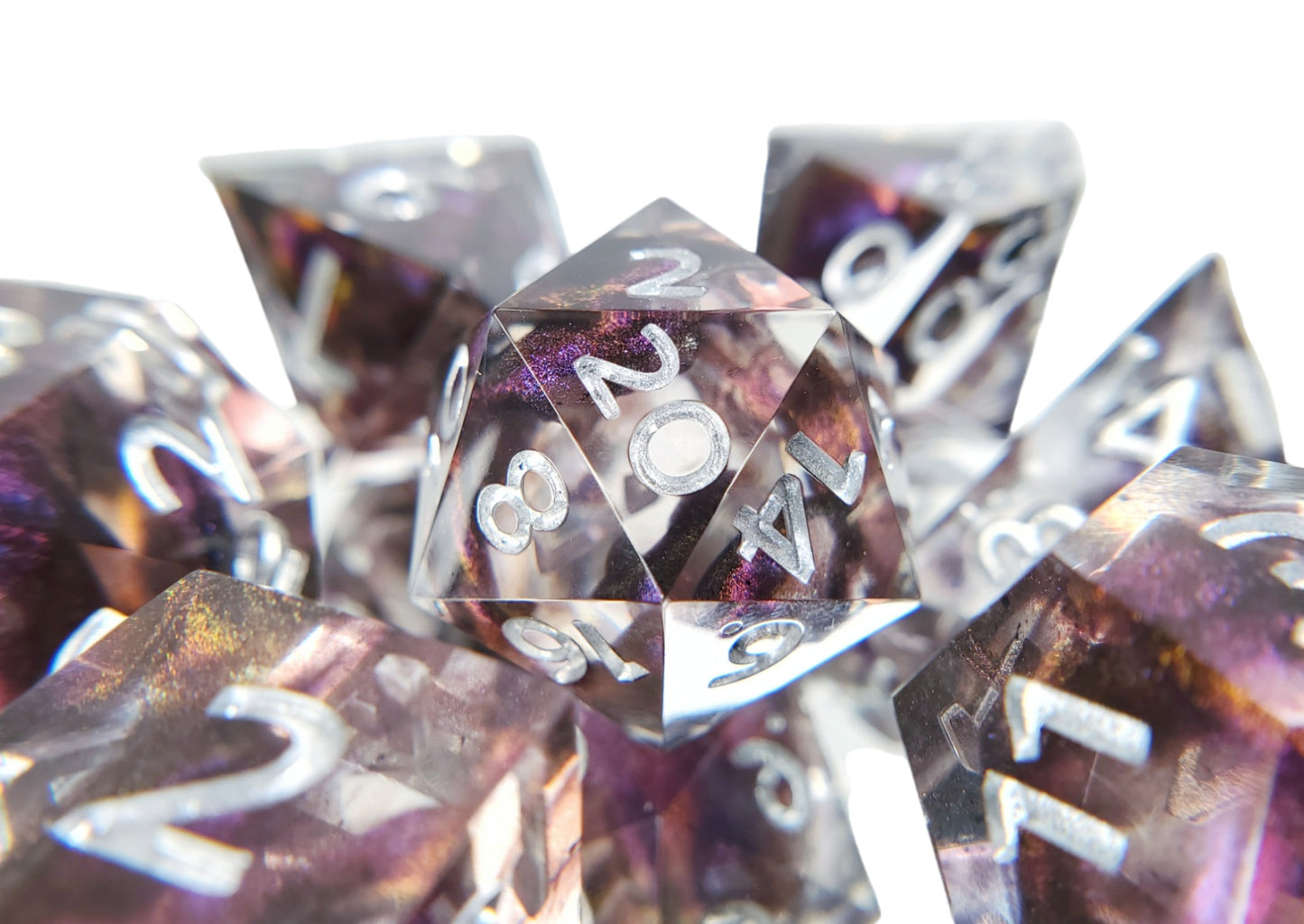 Closeup of the d20 on the dice set of clear resin with dark purple colorshifting shimmer bloops and silver numbering.