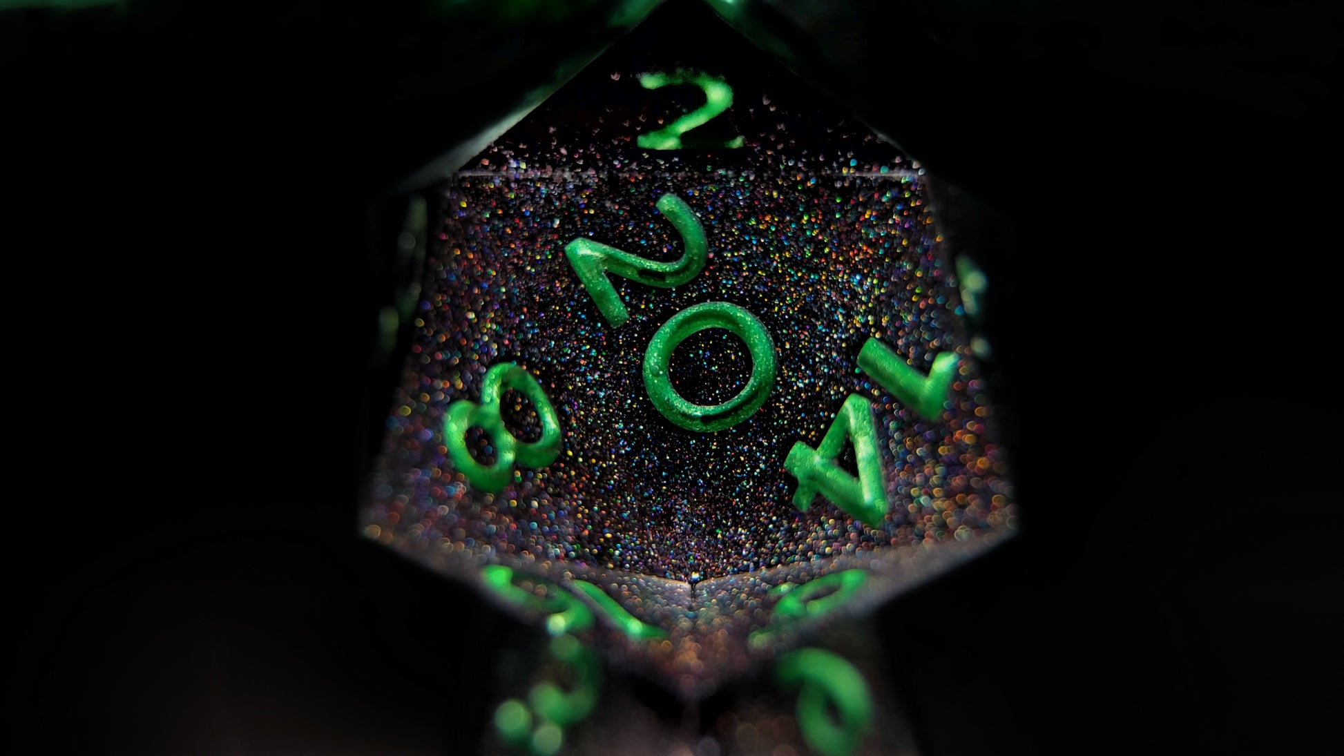 A closeup of a d20 from a ttrpg dice set. The dice are packed with fine rainbow holographic glitter and green metallic numbers.